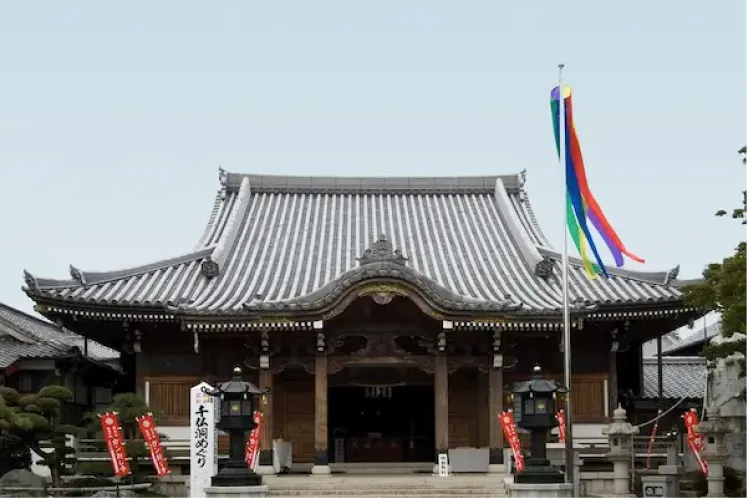 鮮やかな五色の吹き流しが掲げられた無量寺 本堂の外観