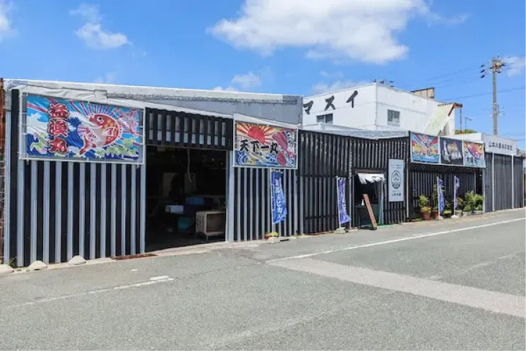 威勢の良い大漁旗が掲げられた地魚販売店「味のヤマスイ」の外観