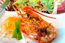 白い皿に盛り付けられた、香ばしく焼き上げられた伊勢海老の鬼瓦焼き。