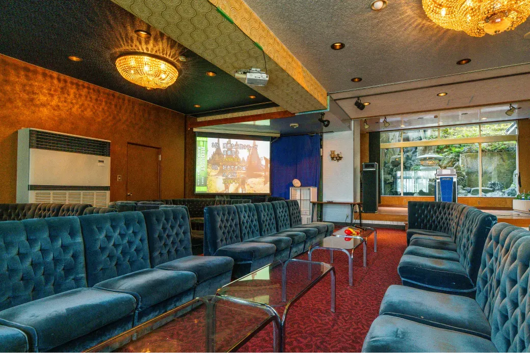 深みのあるブルーのソファが並ぶ、落ち着いた雰囲気のカラオケラウンジ「シーパレス」。