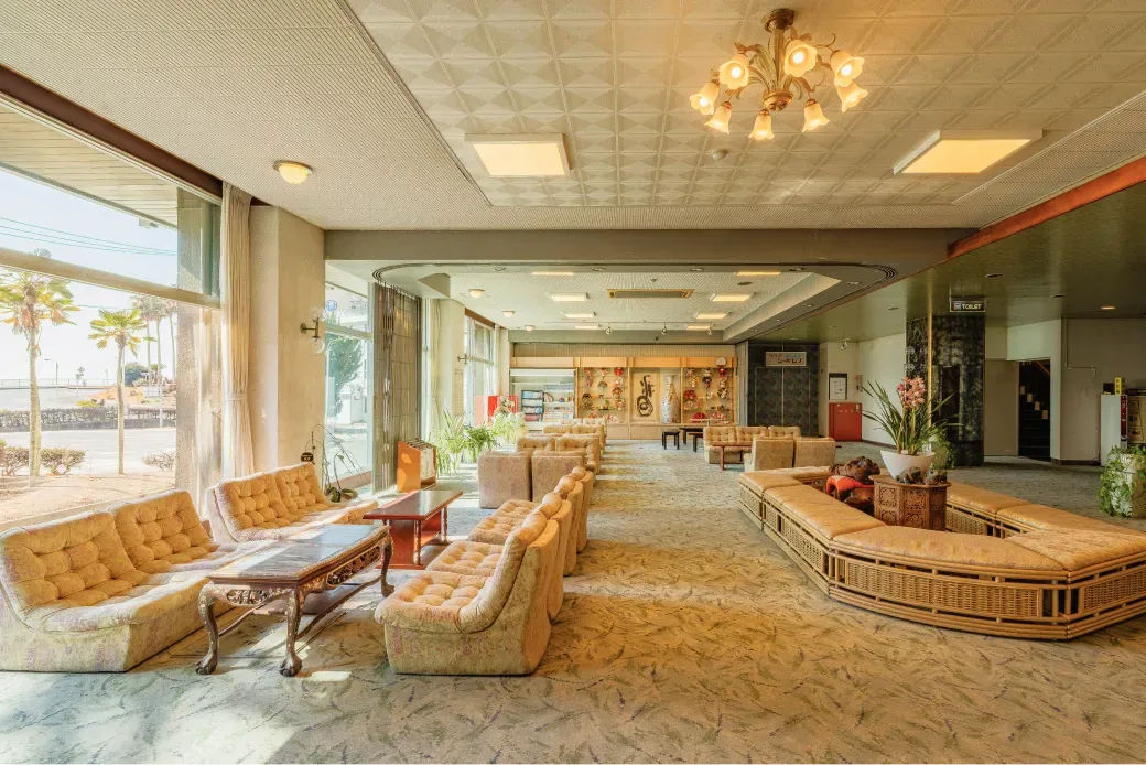 大きな窓から明るい陽光が差し込むフロントロビー。海を眺めながらゆったりと寛げる空間。