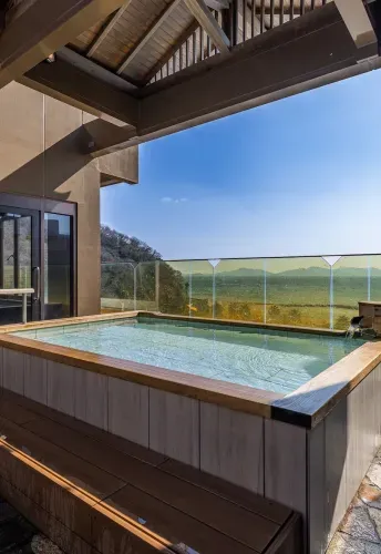 最上階に位置する展望露天風呂。晴れ渡る青空の下、透明なガラスフェンス越しに三河湾の穏やかな絶景を独り占めできる開放的な浴槽です。