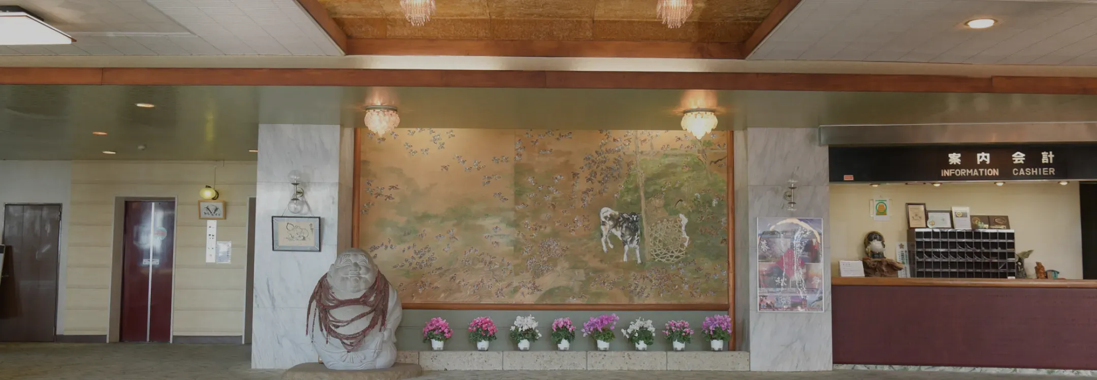 優雅な絵画と石像が飾られた、高級感あふれるホテルのロビーラウンジ正面。