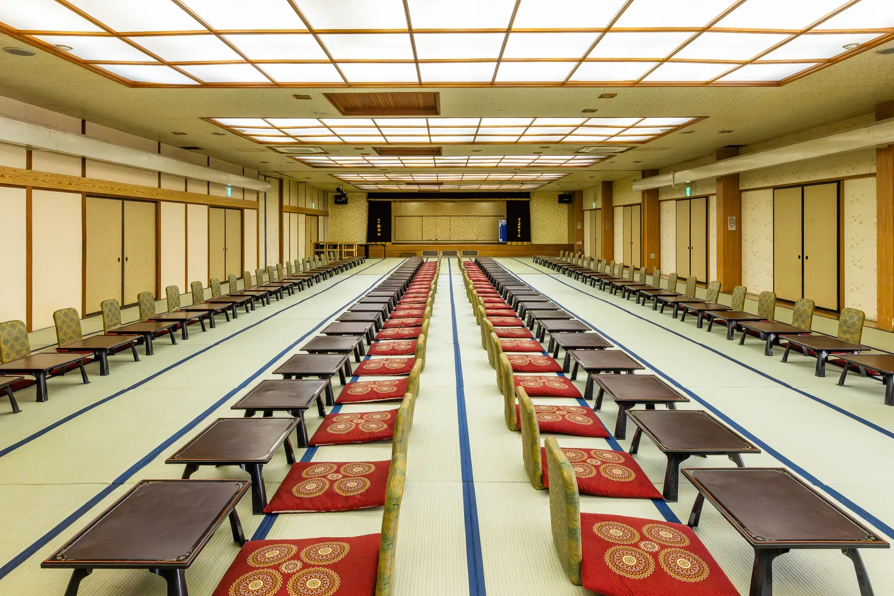 万葉の情緒を感じさせる畳敷きの大宴会場。整然と並ぶお膳が格式高い和の宴を演出します。