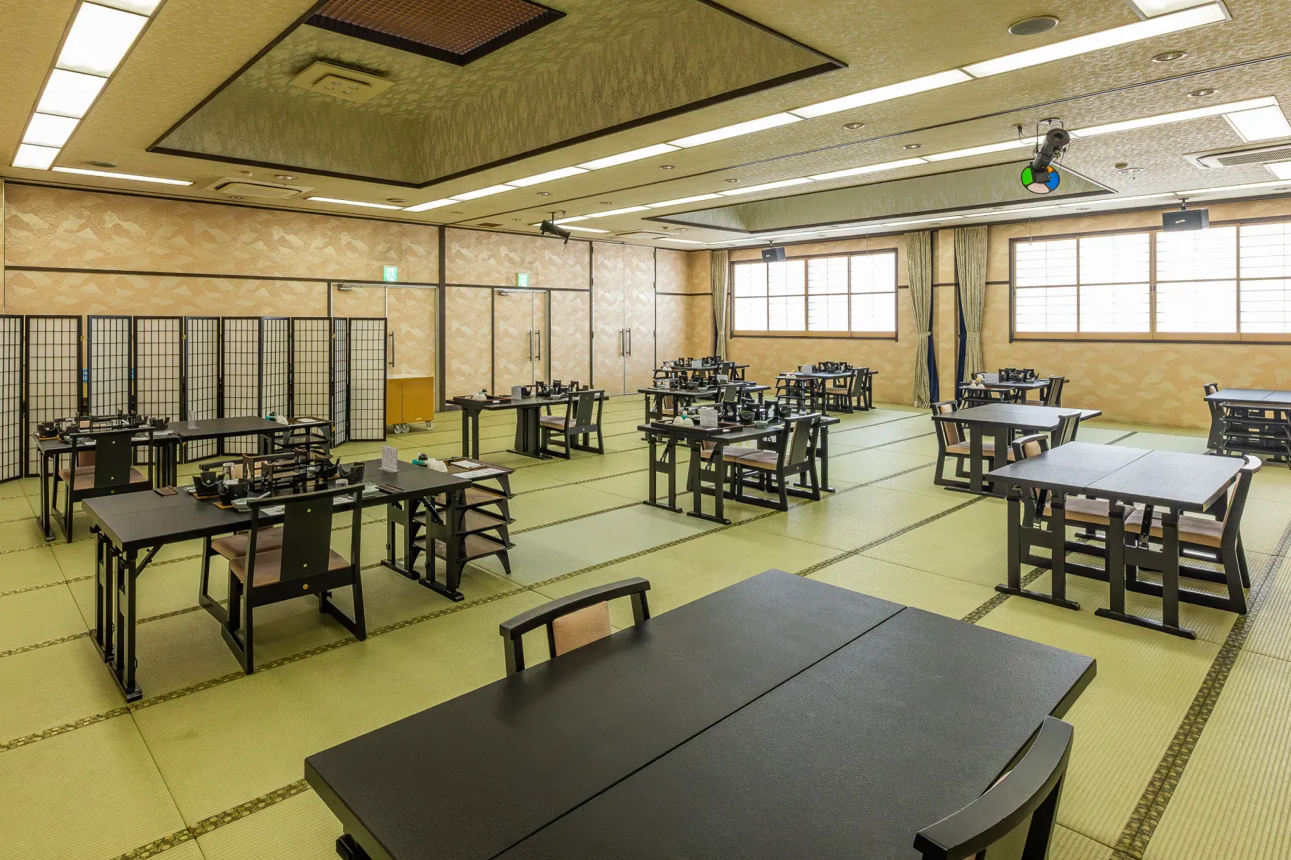 木の温もりと落ち着いた照明が調和した、品格ある畳敷きの宴会場「万葉」の内観。