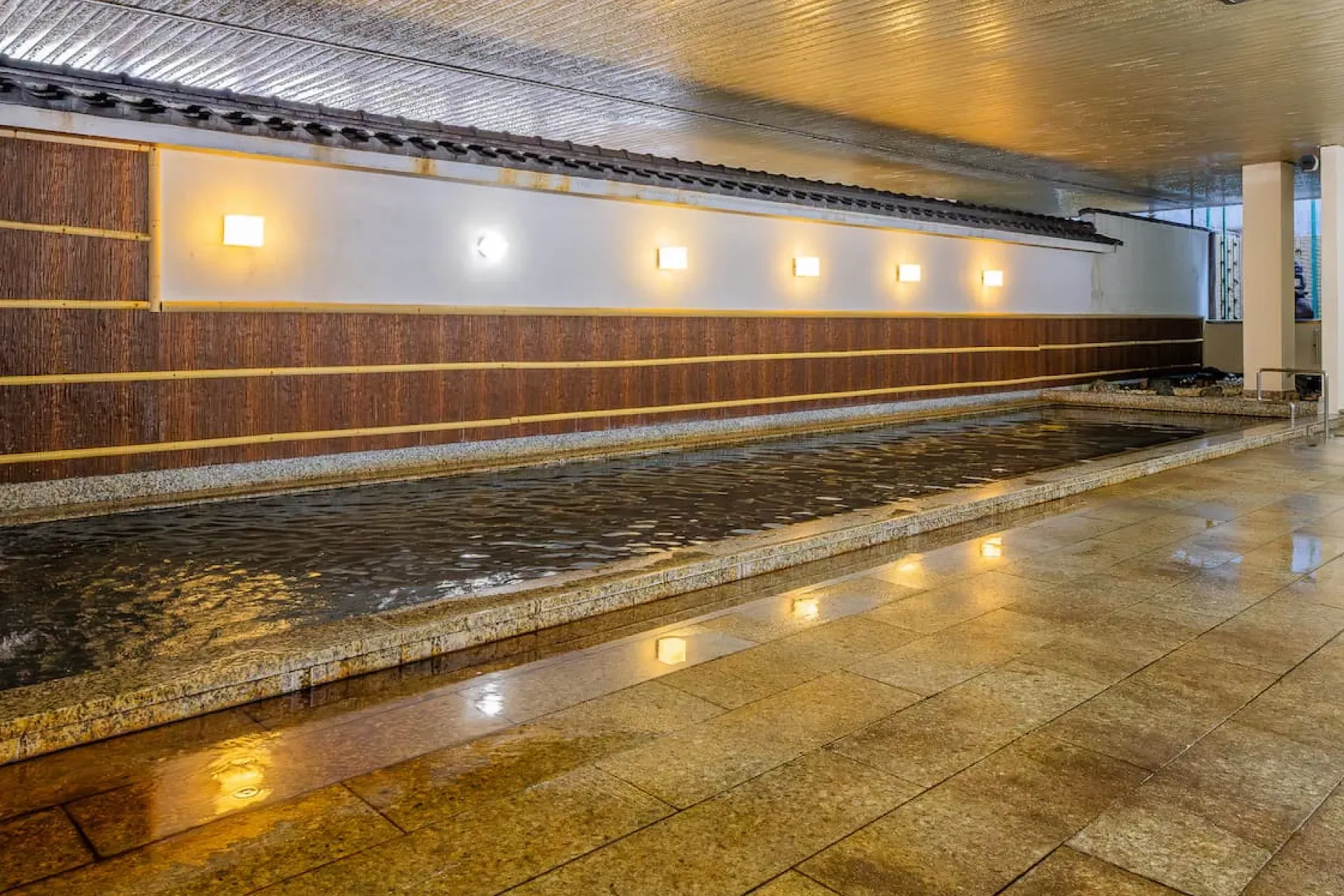 温かみのある照明が水面に映り込む、広々とした落ち着きある大浴場「華厳の湯」。