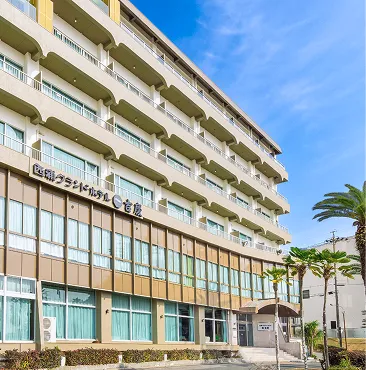 青空を背景に建つ、白と茶色を基調とした多層階の「西浦グランドホテル 吉慶」の外観。