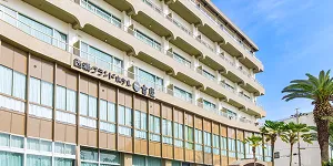 青空を背景に建つ、白と茶色を基調とした多層階の「西浦グランドホテル 吉慶」の外観。