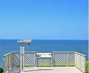 青く澄み渡る三河湾をバックに立つ「真実の鐘」。