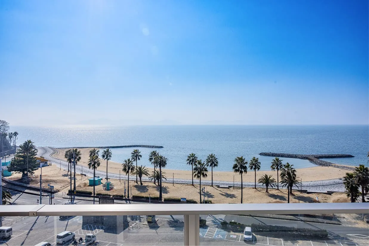 客室のベランダから望むパノラマオーシャンビュー。眼下にはヤシの木が並ぶ白い砂浜のビーチと、穏やかな青い海が広がっています。