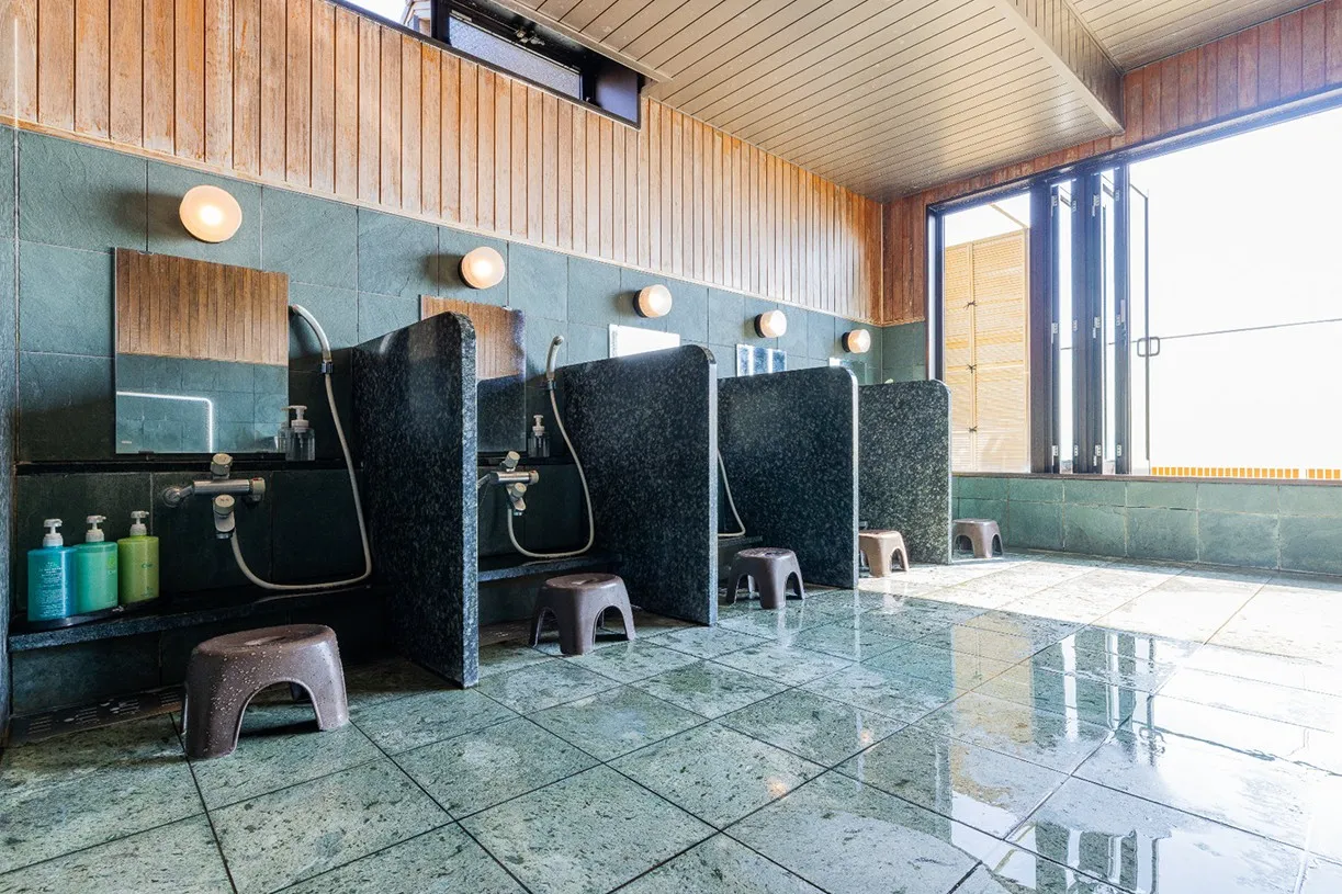 黒い石の仕切り板で区切られた、清潔感のある洗い場。